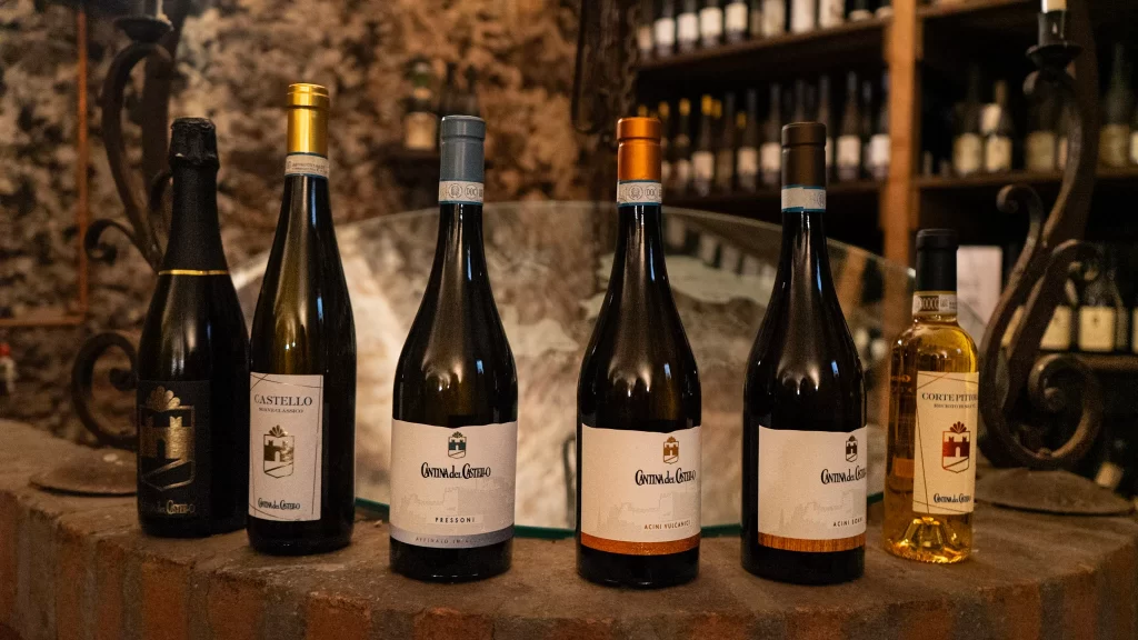 Various dark wine bottles with different labels sitting on a bar