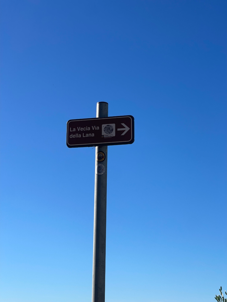 a green sign with the words La Vecia Via Della Lana in Soave Italy