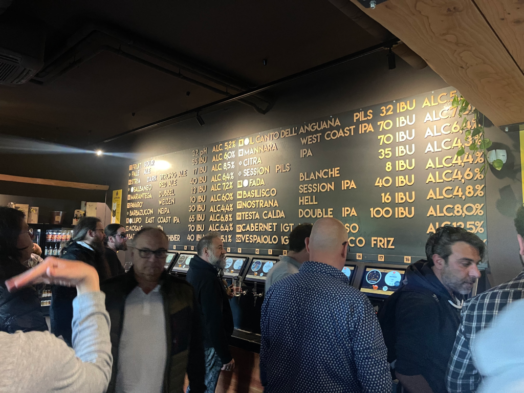Patrons stand in front of the tap listing and tap machines at Luppoland