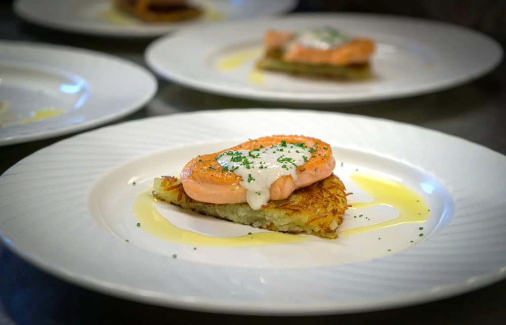 a plate with Rosti and Salmon with oil around it at Trattoria All'Angelo