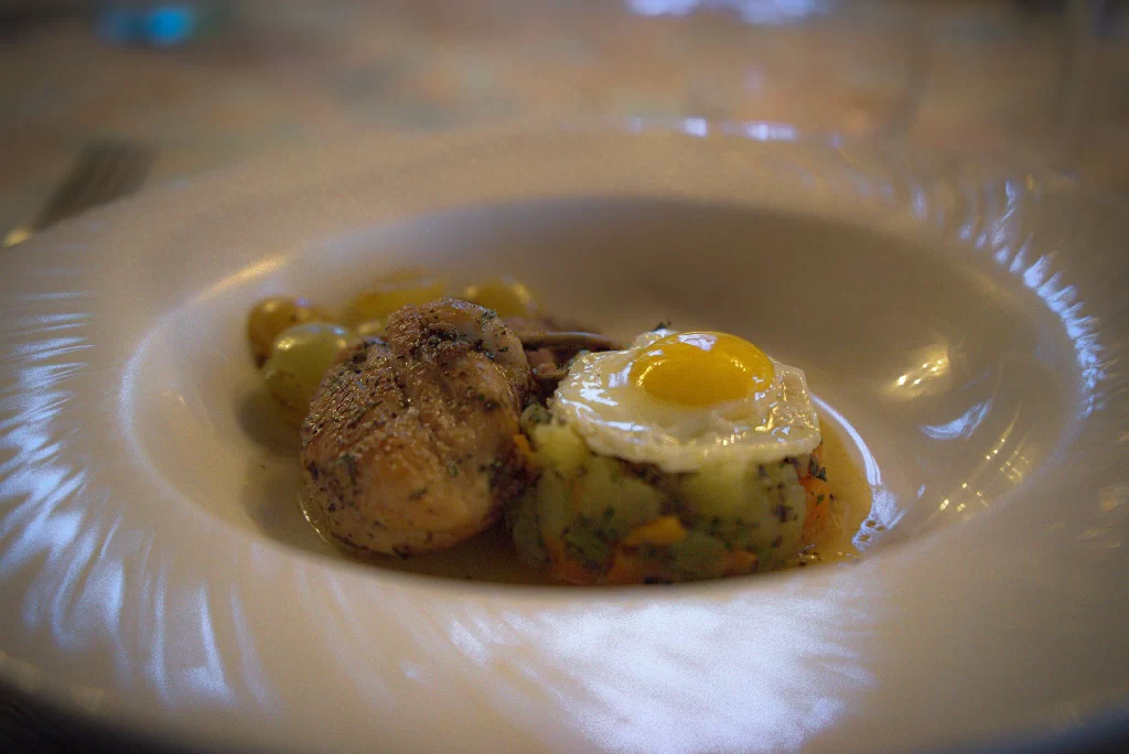 Truffle infused quail with an egg being plated at Trattoria All'Angelo