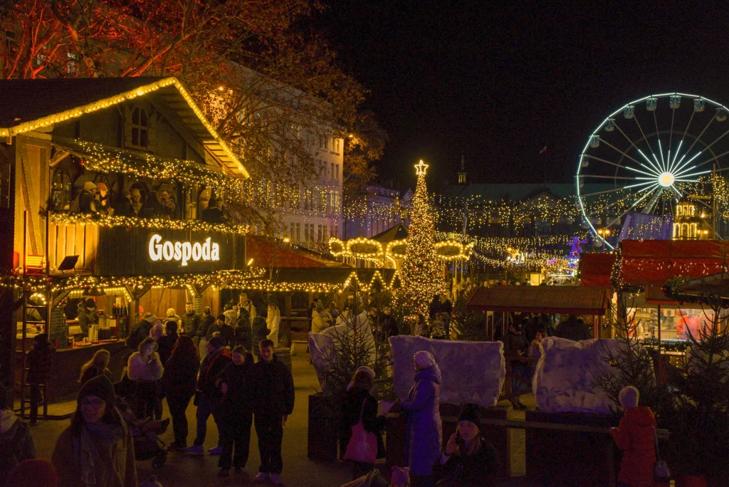 Chalet and different buildings covered in golden christmas lights in the Wolnosc Square of Poznan during christmas 