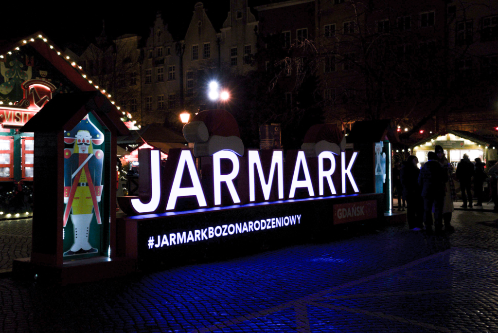 a sign is litup in blue for the Gdansk Christmas Market in Polish the sign says JARMARK