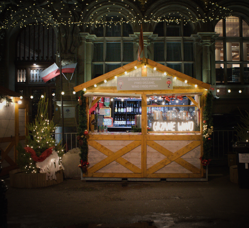 wooden chalet stall at the Gdansk Christmas Market with white christmas lights strung about