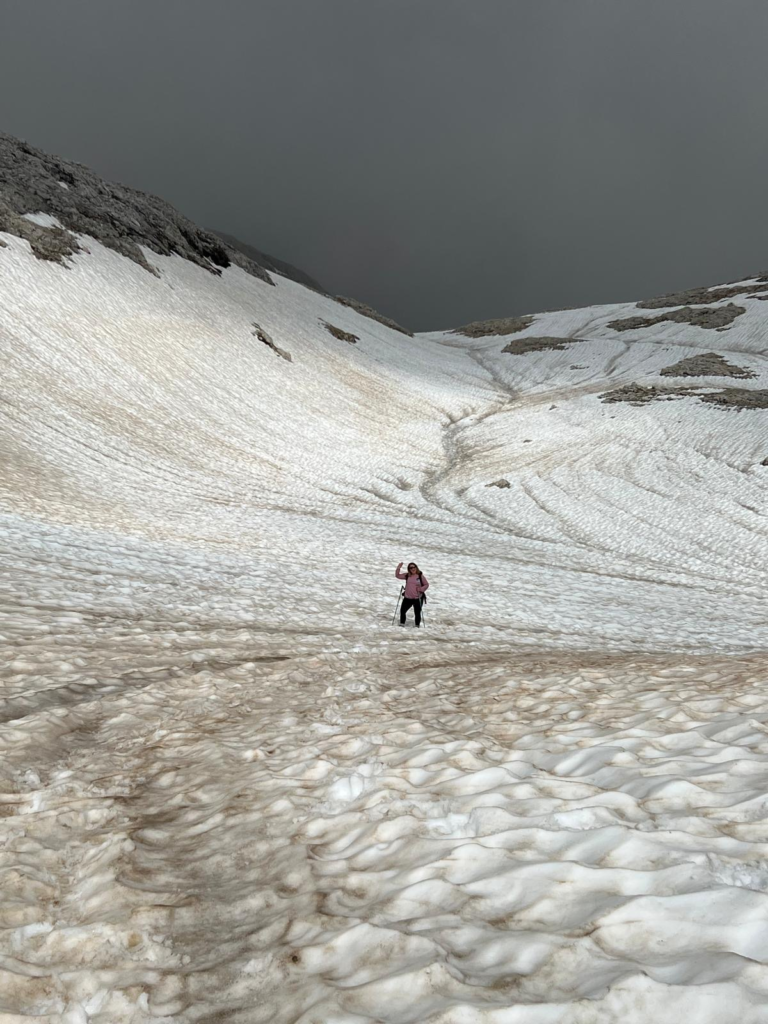 a person traversing through a snow field in the Pale Di San Martino on the trail to Rifugio Pradidali