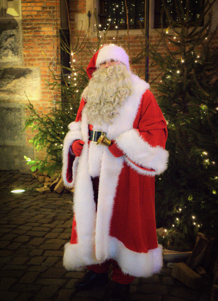 Santa in a red and white gown posing for a picture