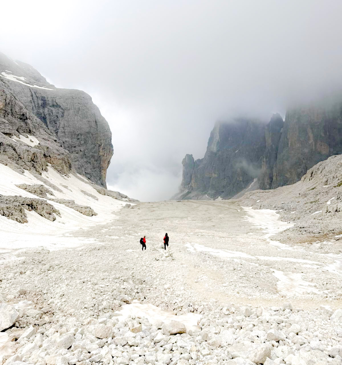 The Pradidali basso filled with scree and towering cliffs on a foggy day in the Dolomites in the Pale Di San Martino