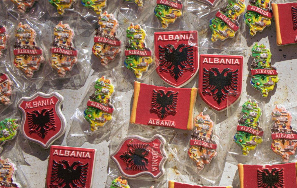 magnets on a whiteboard with different designs that say Albania on them