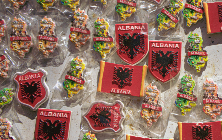 magnets on a whiteboard with different designs that say Albania on them