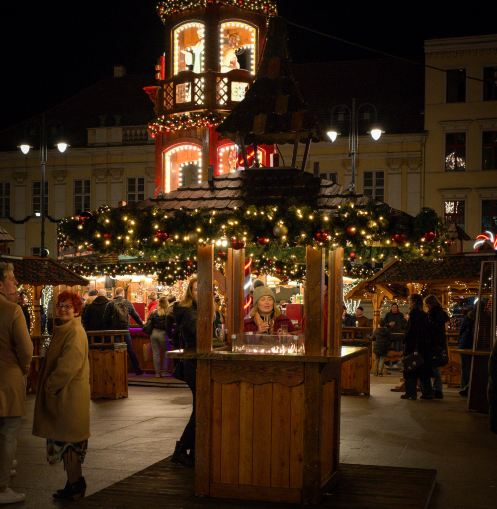 A cozy christmas chalet scene with a christmas pyramid in the background at the bydgoszcz Christmas Market