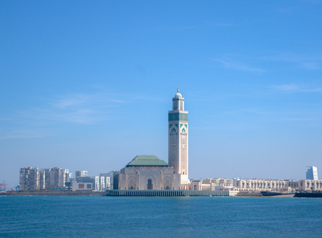 a view of the Hassan II Mosque in Casablanca from the waterfront on a sunny day