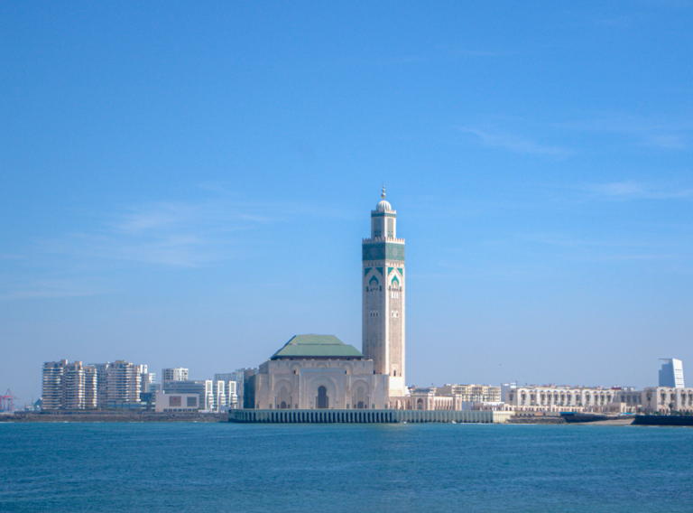 a view of the Hassan II Mosque in Casablanca from the waterfront on a sunny day