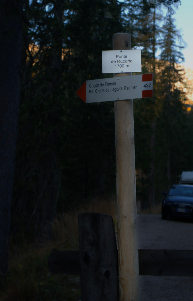 The trail marker shown in the dawn light of morning with the words Croda Da Lago On it