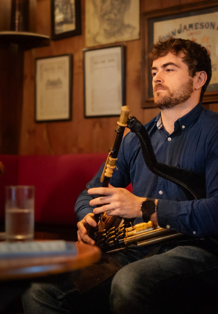 Man holding a traditional instrument at a pub in Ireland