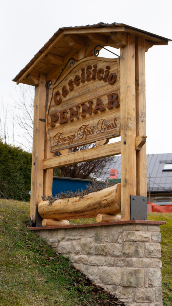 a wooden sign that says CASEIFICIO PENNAR