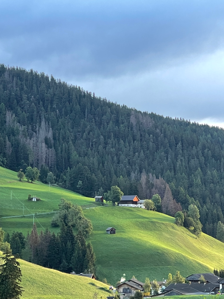 A Beautiful Meadow scene with the sun shining down on an old south tyrol church in the Dolomites.