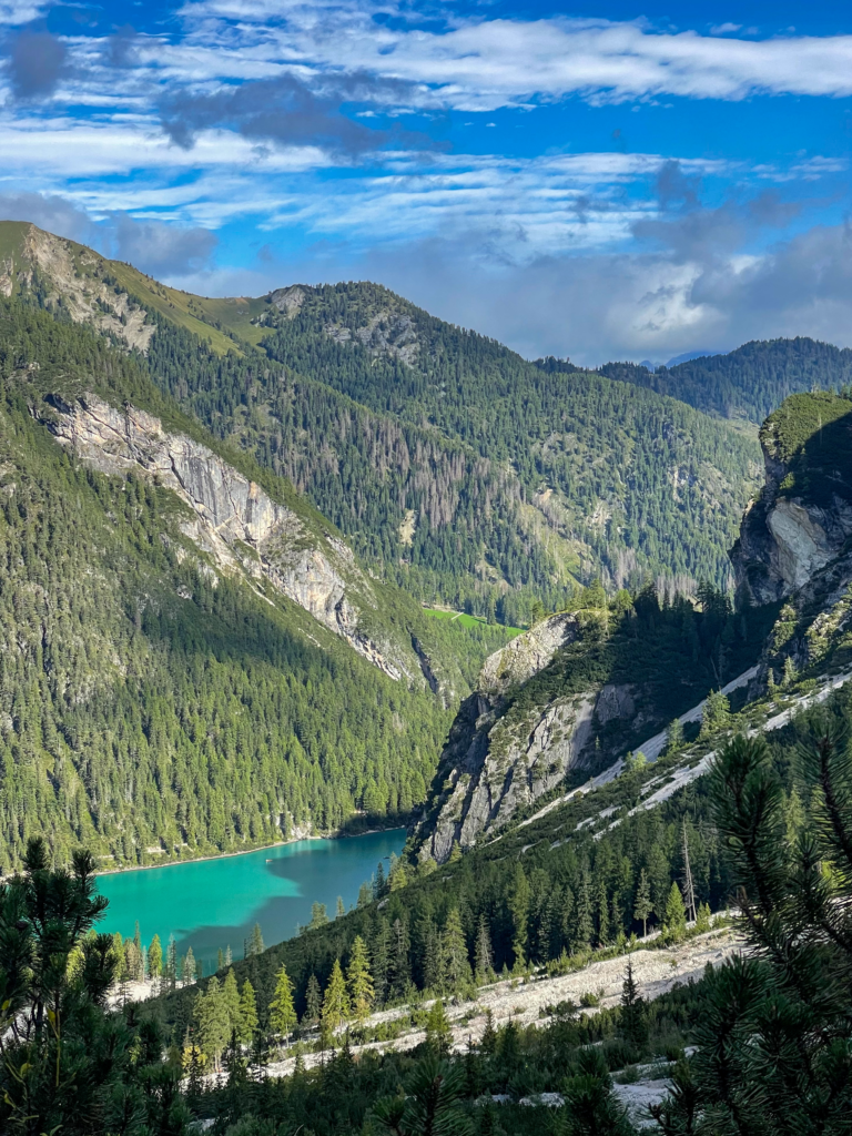 a turqouise mountain lake, Lago Di Braies lit up by the sun in a serene mountain setting in the Dolomites on the Alta Via 1