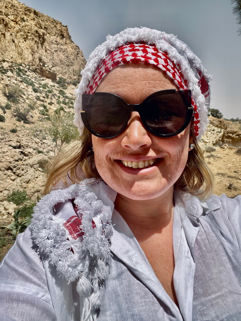a woman with a keffiyah smiling at the camera in Dana Jordan