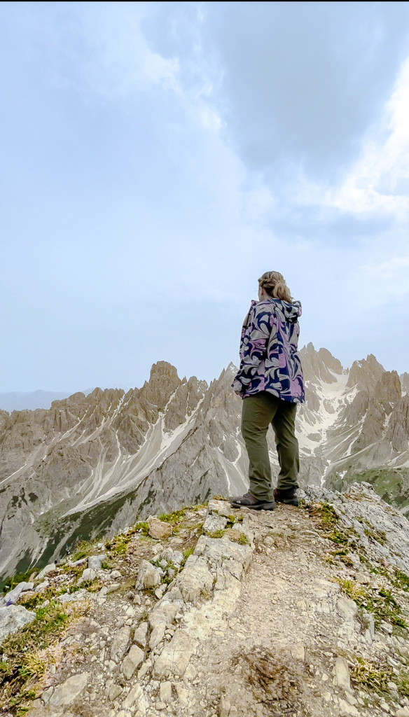 A Woman Standing on the Ledge of a Mountain near Cadini Di Misurina