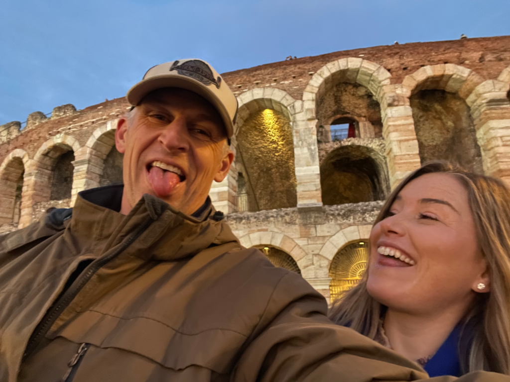 a man sticking his toungue out with a woman looking at him and laughing