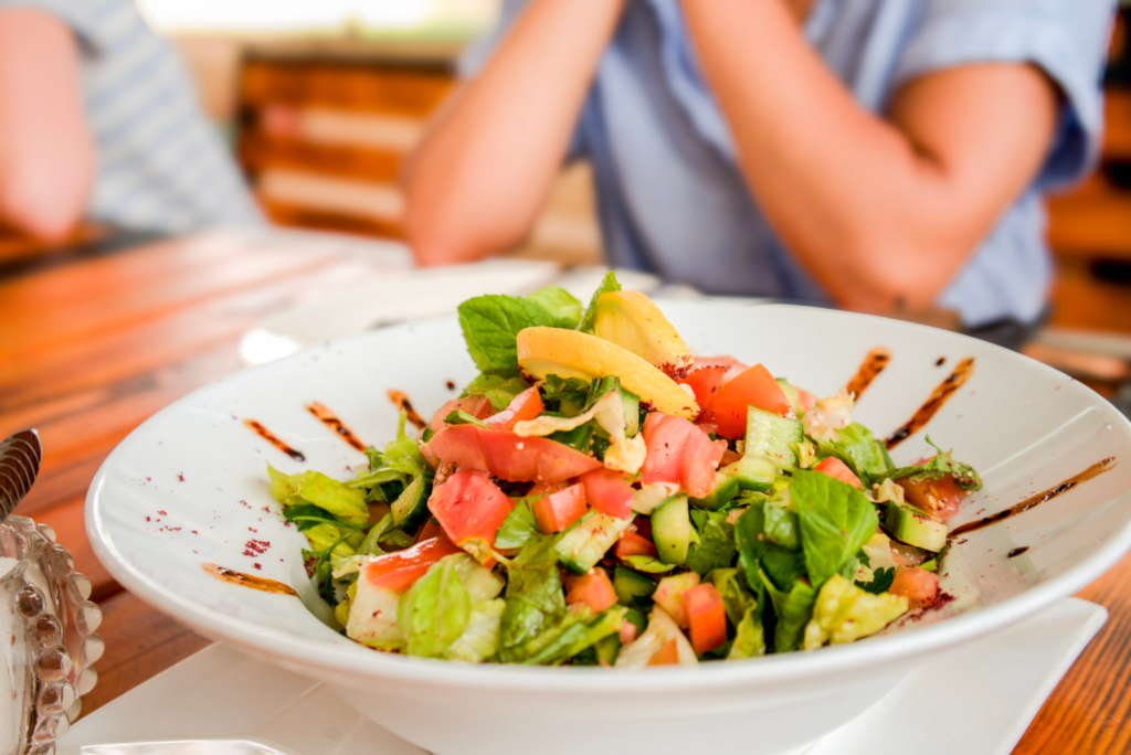 middle eastern salad sitting in a white bowl at a table