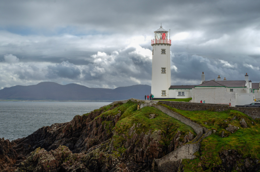 Fanad lighthouse sits on a rocky outcrop in Donegal, Ireland with clouds around it