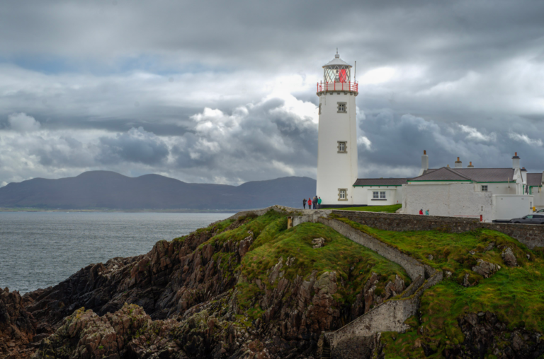 Fanad lighthouse sits on a rocky outcrop in Donegal, Ireland with clouds around it