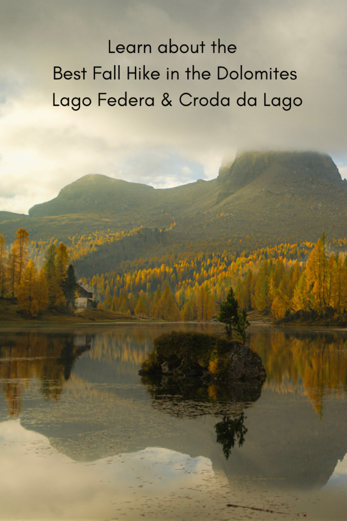 a beautiful serene lake view with the dolomites rising against the background and beautiful fall foliage reflecting on the lake