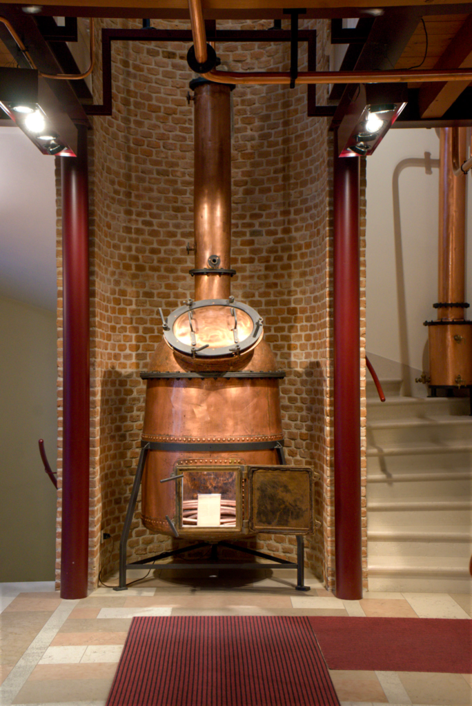 a traditional grappa distillery machine on display in a museum at Poli Grappa