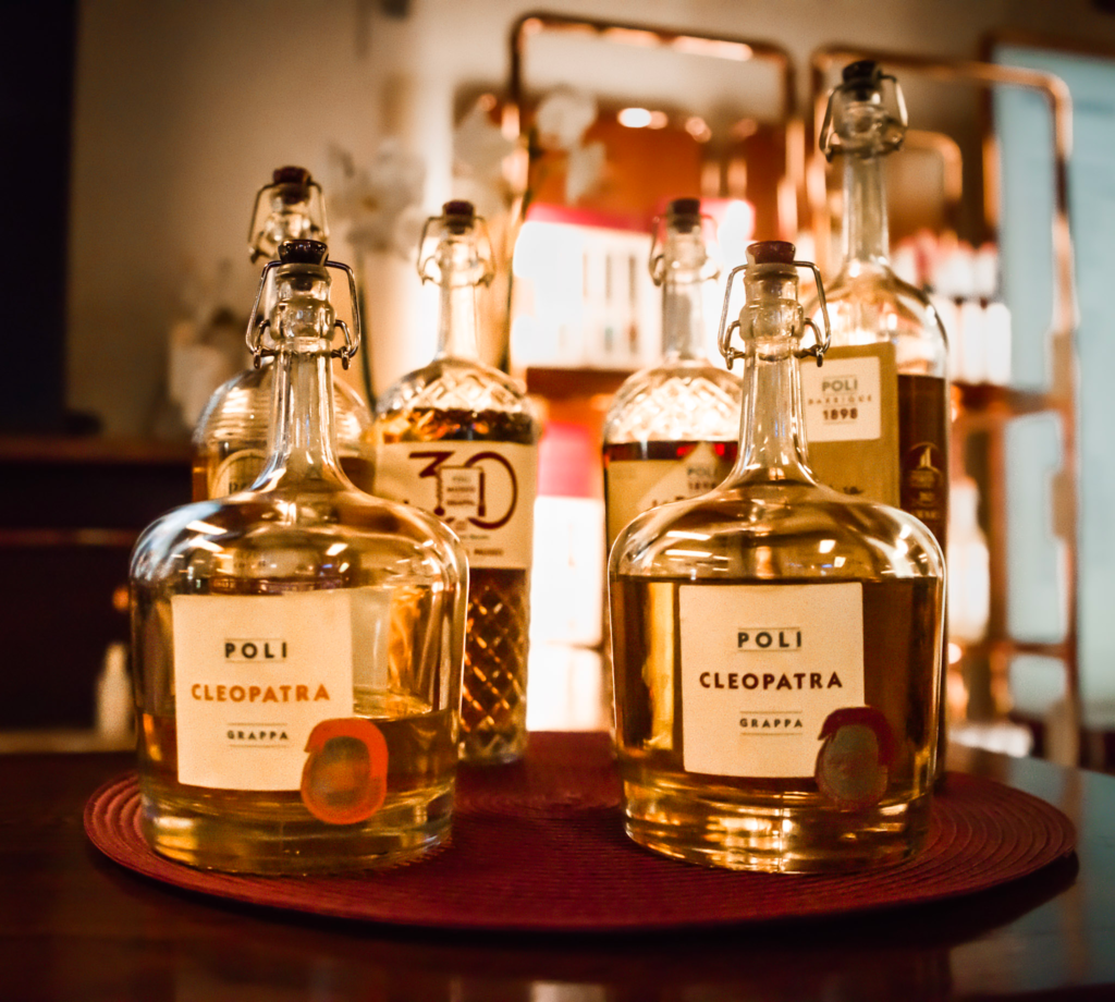 a selection of bottles from Poli Grappa with liquid in them