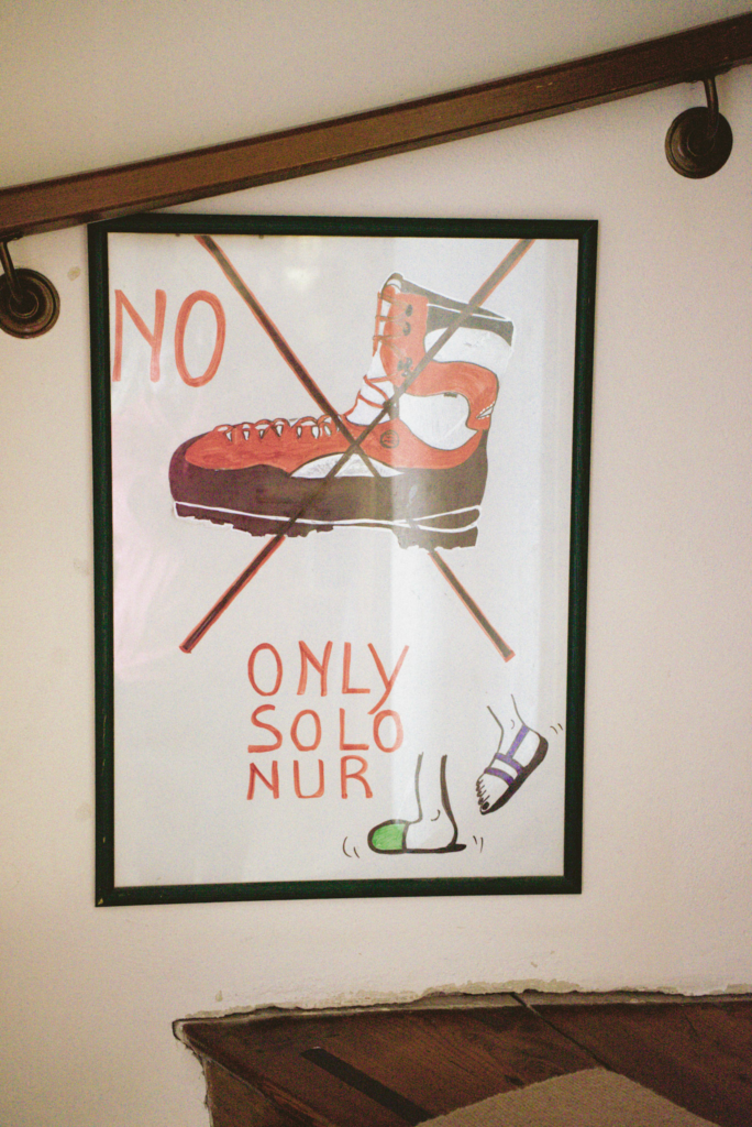 a sign on a stairwell that says NO BOOTS ONLY SOLO NUR SANDALS