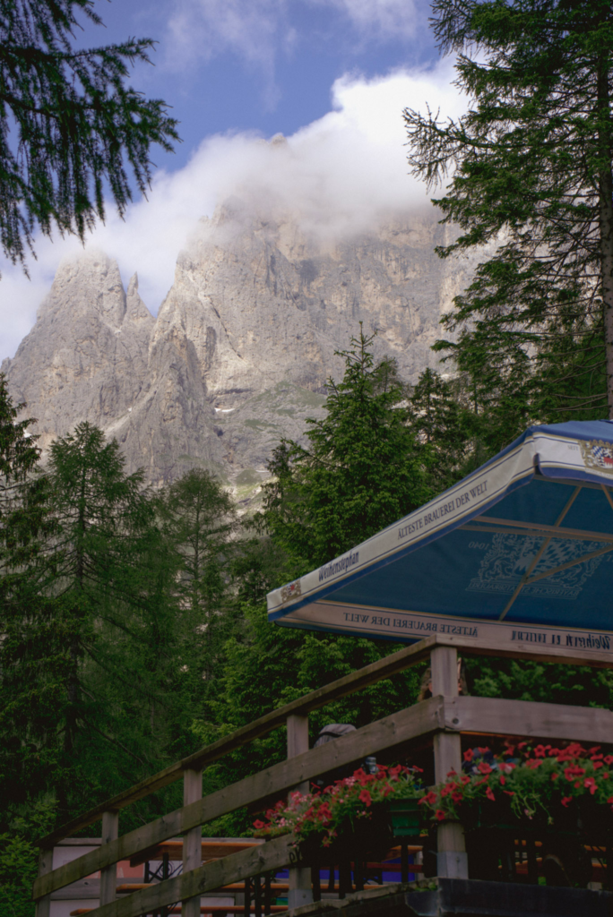 Rifugio Treviso Patio with a blue and white umbrella set against and alpine backdrop