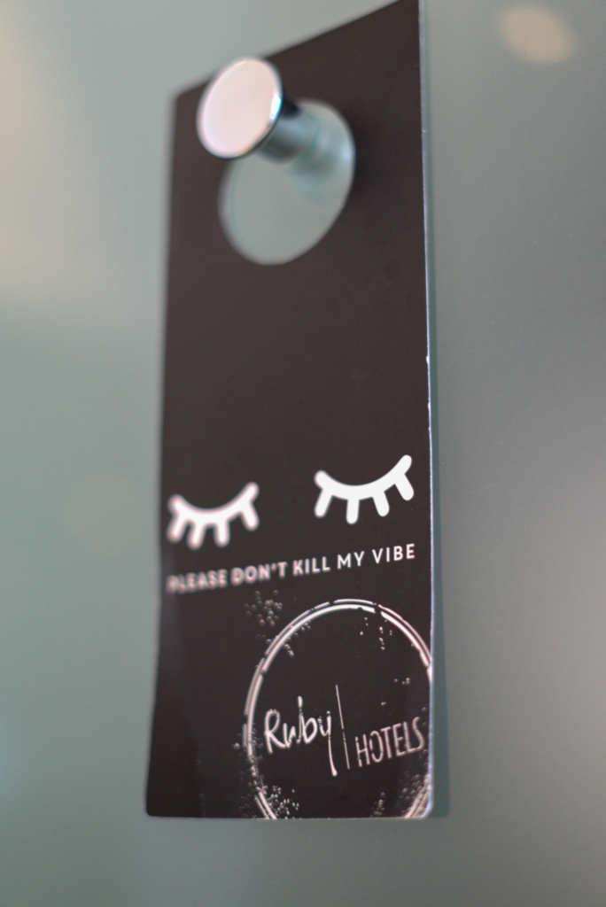 a black placard hanging on a silver know that says do not disturb