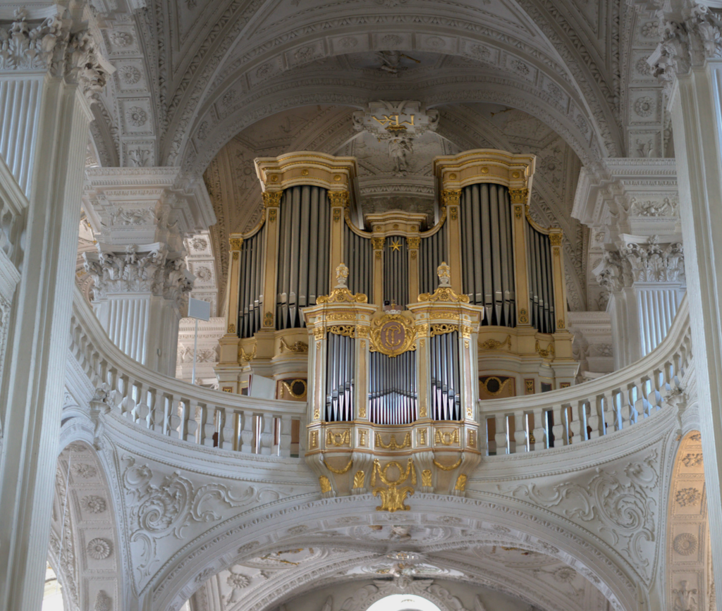 Organs of a church hang over the church pews and on lookers look up at the St. Andreas Church in Dusseldorf