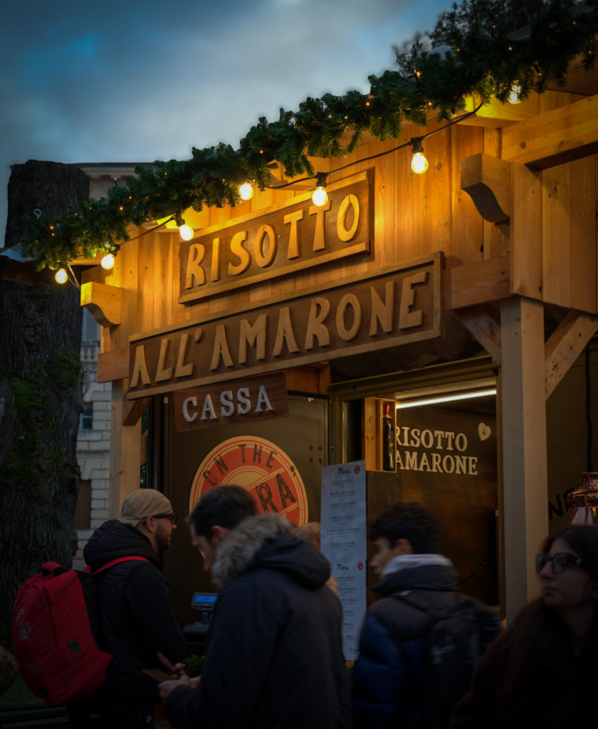 a lit up sign that says in italian Risotta Al Amarone (risotto with amarone)