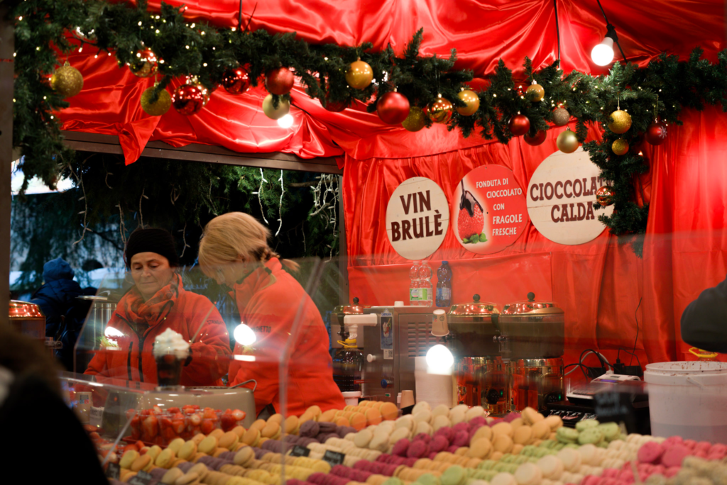 two women serve hot chocolate at a market stall in verona italy at the christmas market