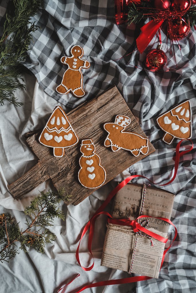 A cozy arrangement of gingerbread cookies and wrapped gifts on a rustic wooden board, perfect for the holiday season.