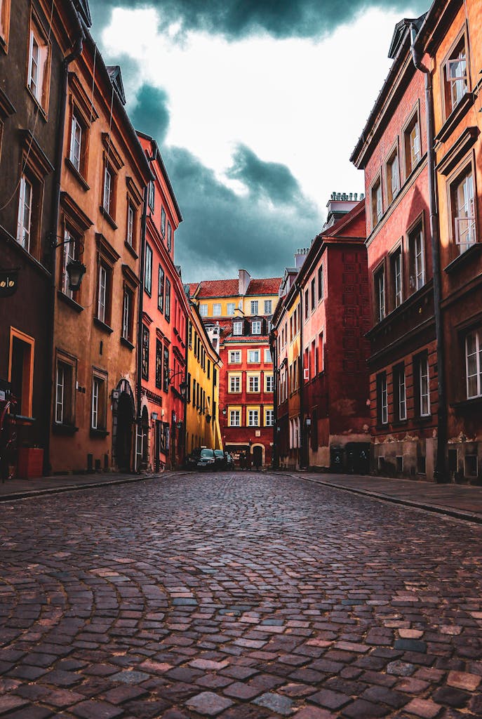 Dramatic view of cobblestone street in Warsaw's Old Town, showcasing colorful historic architecture.