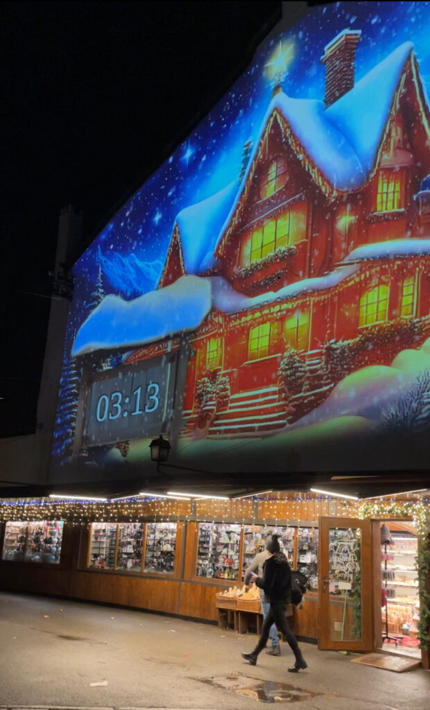 light mapping on side of building with the numbers 3:13 counting down till the next light show in Aosta, Italy