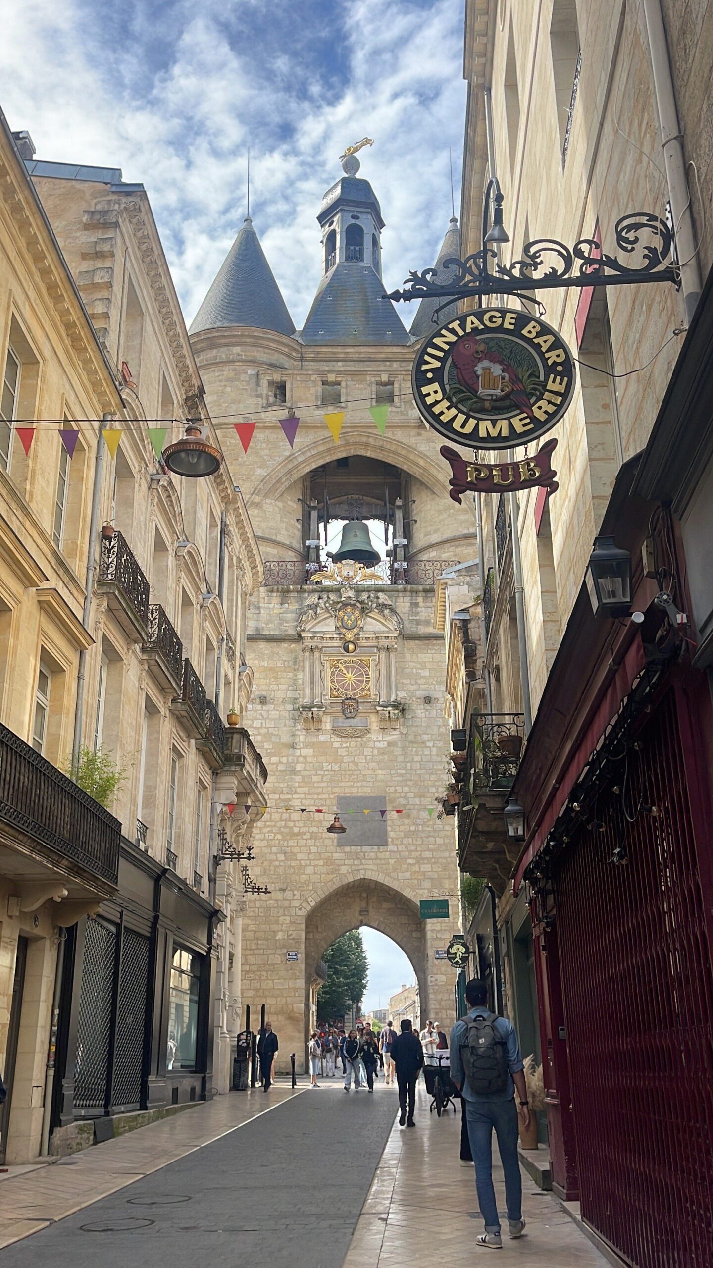 View of the 18th Century Bell Tower in Bordeaux with a blue sky and passerbys on the street