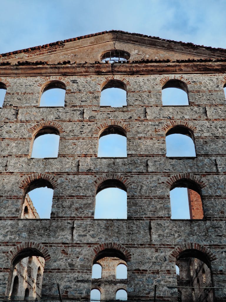 Vertical view of the Roman theater ruins in Aosta, Italy, showcasing historical architecture.