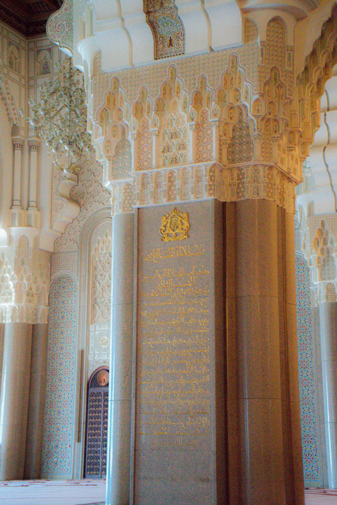 a pillar in hassan II mosque with gold inscription in arabic