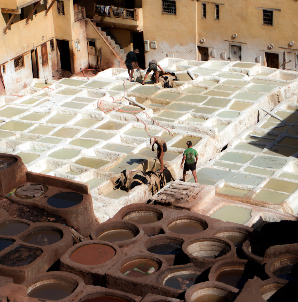 three men pull a hose over the dying pools in cChefchaouen