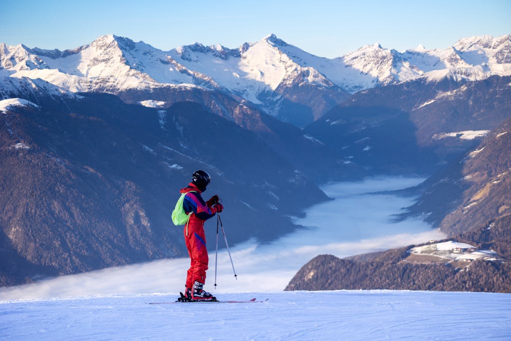 Skier enjoying a scenic view of the snow-covered Italian Alps. Perfect winter adventure.