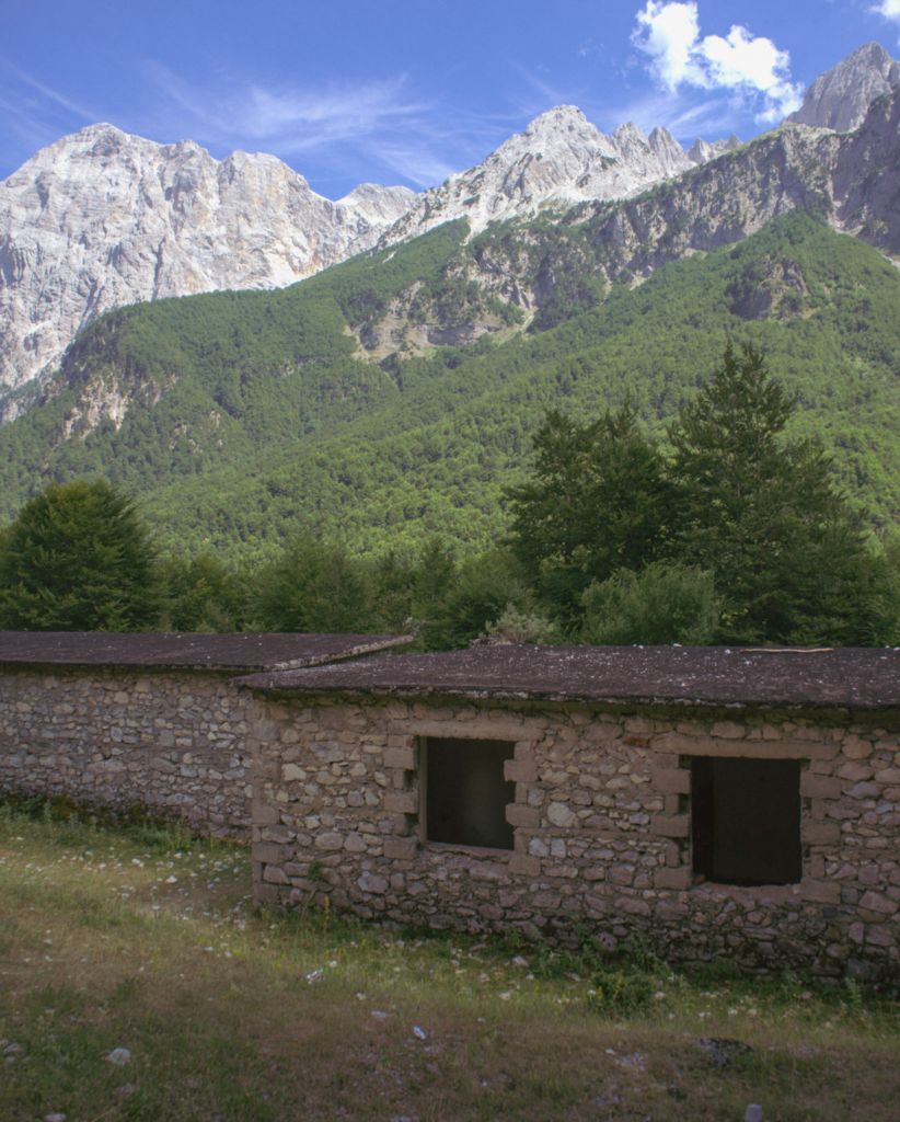 an empty stone house set against an alpine backdrop in Valbone Albania