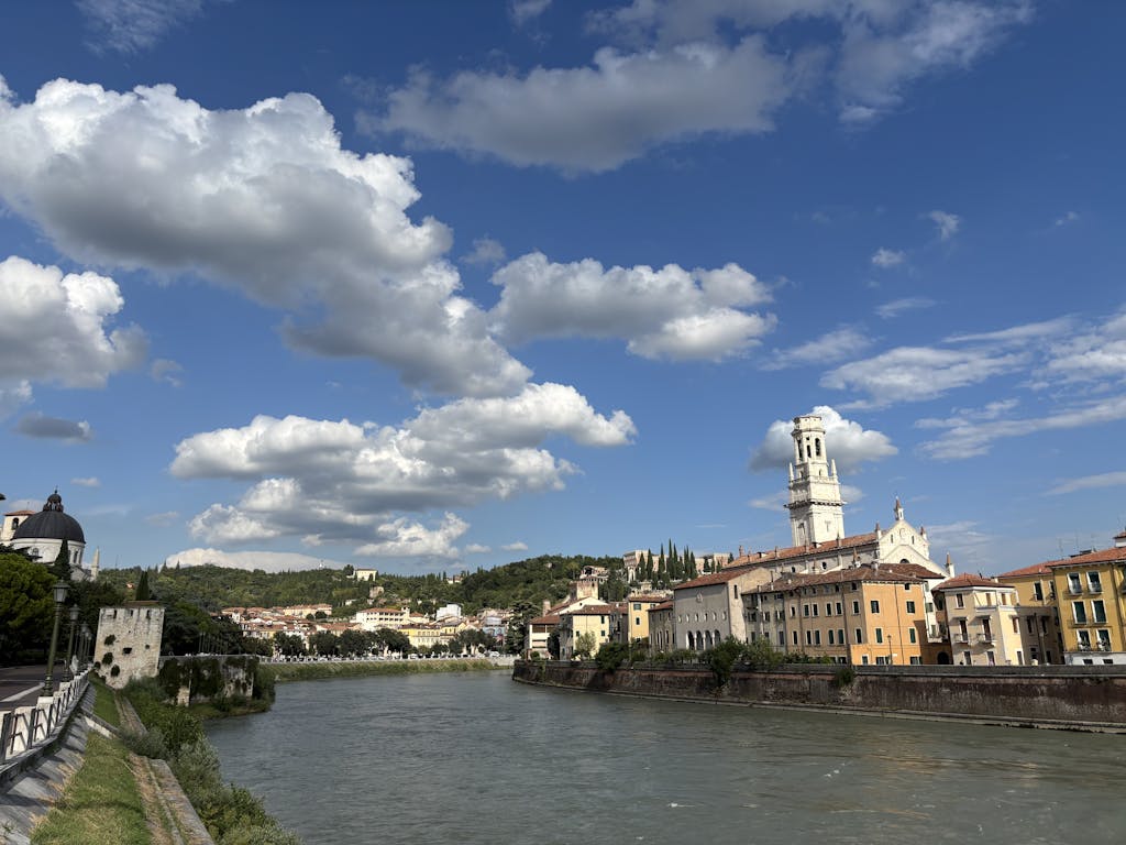 A beautiful day in Verona, Italy with vibrant sky and historic architecture by the river.