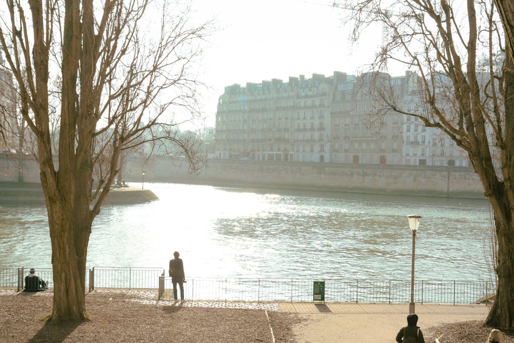 A serene morning walk by the Seine River in Paris, capturing the calm beauty of the city.