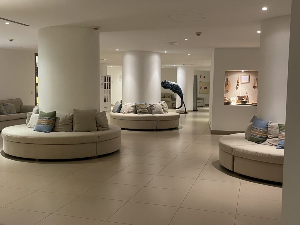 Bright, modern hotel lobby at Memmo Baleeira in Sagres with circular sofas, soft lighting, and a minimalist design that sets a calm tone for a hotel in the Algarve review.