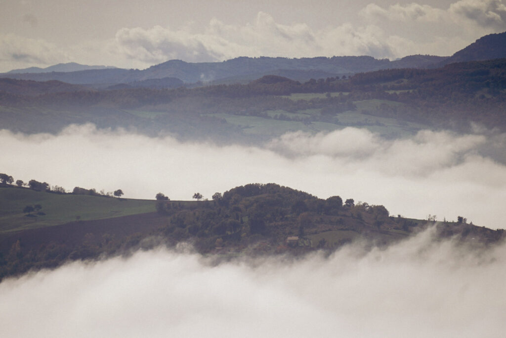 Rolling hills and patchwork fields peek through low clouds and fog, showcasing the sweeping views that define 2 days in San Marino.