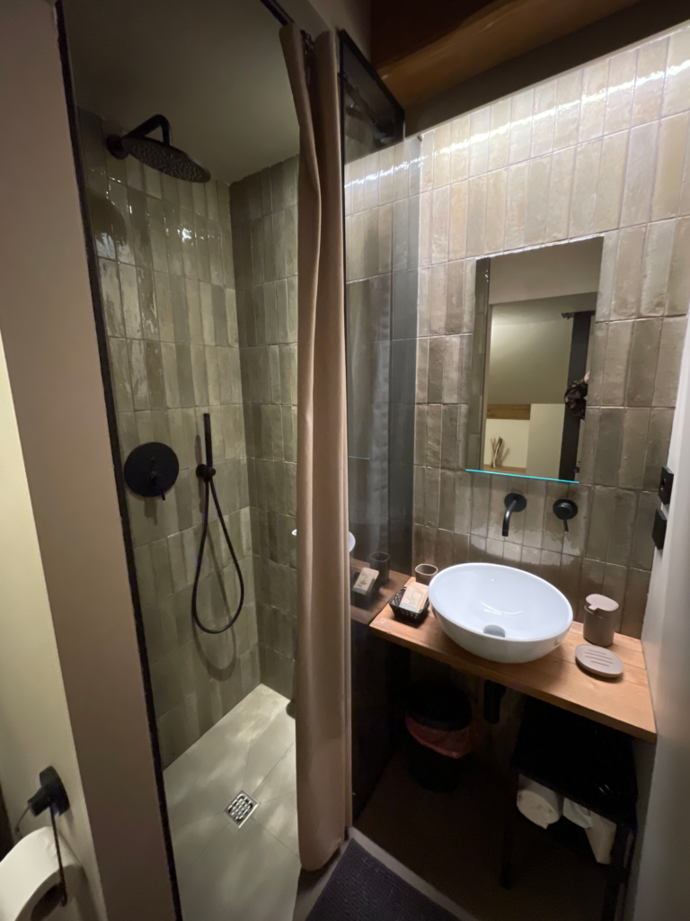Modern bathroom at Casa Cicetta with walk in shower, rainfall showerhead, and tiled walls paired with a wooden vanity during a 2 days in San Marino stay.